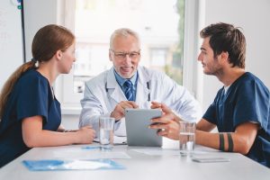 Doctors and nurses looking at digital tablet during medic meeting in hospital